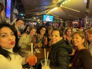 People enjoying cocktails on a terrace bar stop during the Budapest Pub Crawl